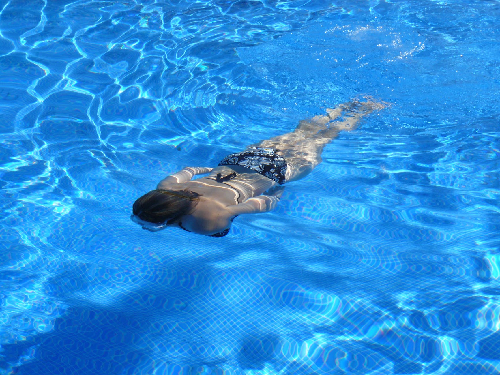 A woman enjoying a swim, which can be helpful for pain management.