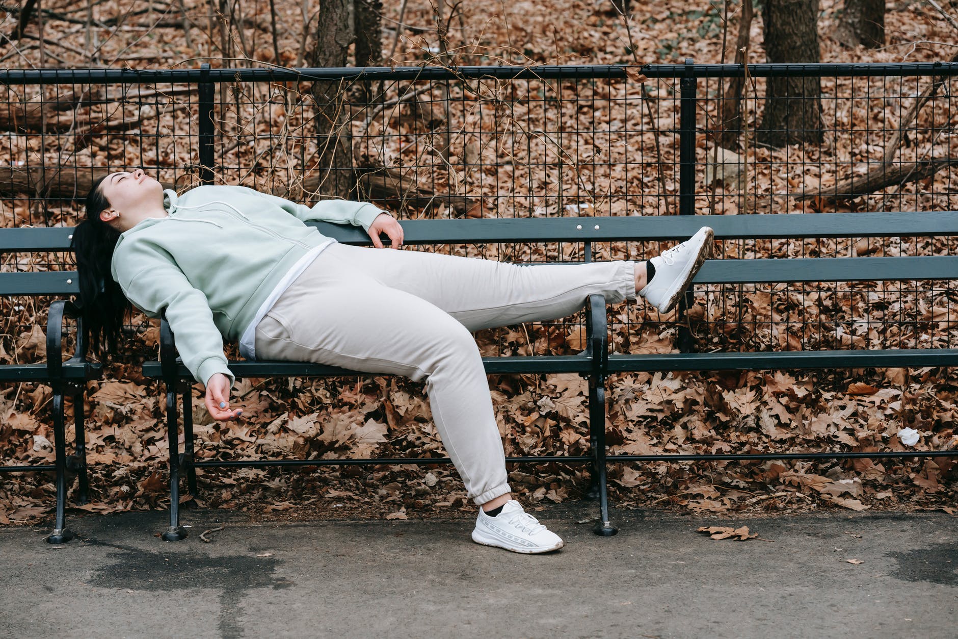 An exhausted woman rests on a park bench